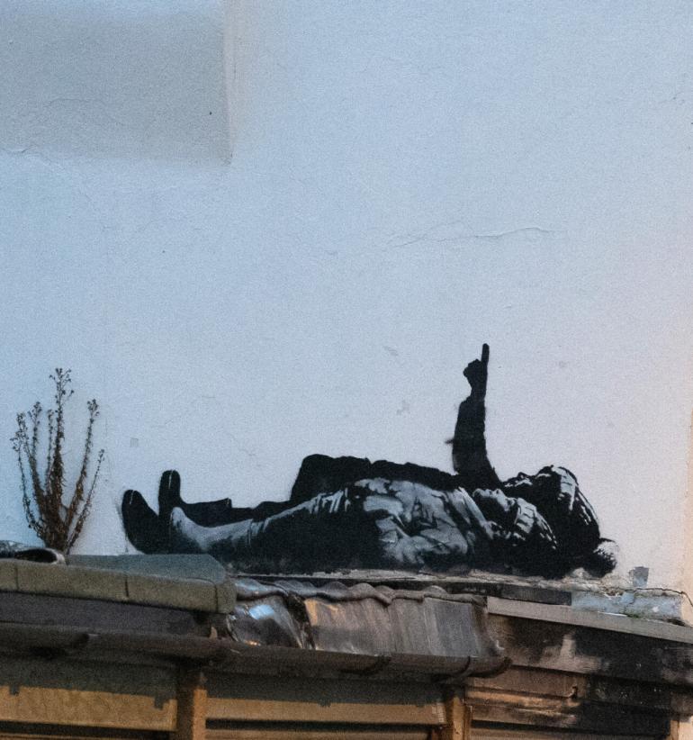 Undatiertes, von Banksy veröffentlichtes Handout-Foto eines neuen Kunstwerks des Künstlers. Die Arbeit zeigt zwei Kinder, die an der Seite eines Gebäudes im Londoner Stadtteil Bayswater auf einem Dachvorsprung liegen und in den Himmel blicken. © Foto: Banksy